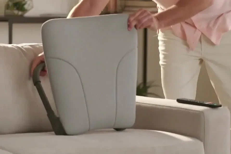 A man setting an opened Deluxe Ready Rocker onto a sofa